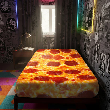 A bed with a printed pizza-pattern mattress cover or bedding, shown in a styled bedroom setting with a nightstand, lamp, curtains, and window.