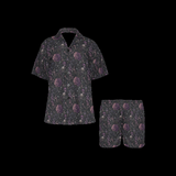 Front view of black night floral women's pajama shirt and shorts with purple skull-and-flower print on a black background